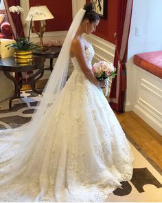 a woman in a wedding dress is looking down at her bouquet