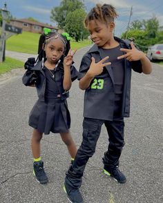 two young children standing in the middle of a street