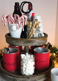 some candy canes and marshmallows are in tins on a tray