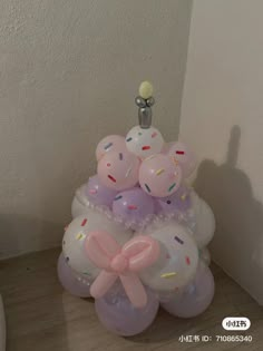 balloons are stacked on top of each other in the shape of a tower with bows