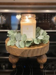 a lit candle sitting on top of a wooden stand