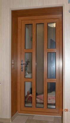 a wooden door with glass panels in a room