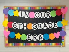 a blackboard with the words in our 6th grade era on it and colorful paper hearts