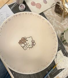 a hello kitty plate sitting on top of a table next to other plates and utensils