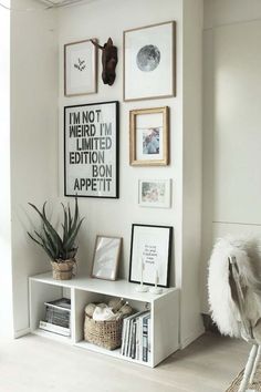 a living room with white walls and pictures hanging on the wall, including an animal head