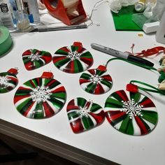 a table topped with green and red candy canes on top of a white counter