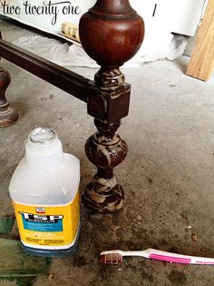 a bottle of toothpaste sitting on the ground next to a brush