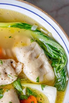 a bowl filled with soup and vegetables on top of a table