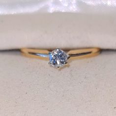 an engagement ring with a blue diamond in it sitting on a white cloth covered pillow