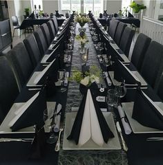 a long table set with black and white place settings