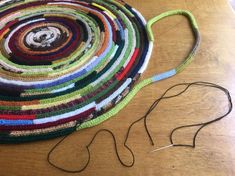 there is a large multicolored rug on the table next to some scissors and thread