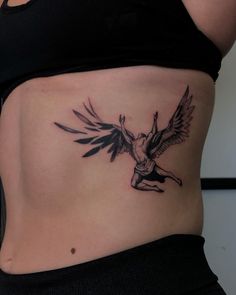 a woman's stomach with an angel tattoo on her belly and the bottom part of her abdomen