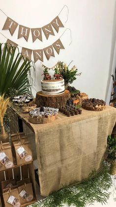 a table topped with cake and desserts on top of wooden crates next to a plant