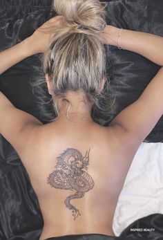 a woman with a dragon tattoo on her back