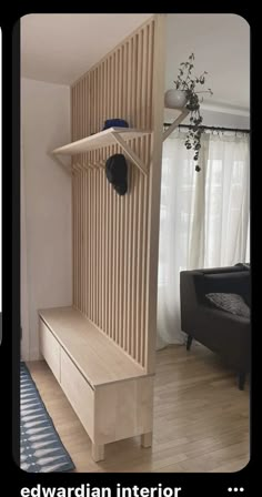 there is a wooden bench in the middle of this living room with a black chair