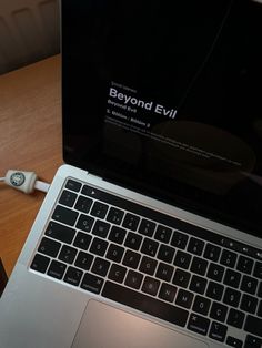 an open laptop computer sitting on top of a wooden desk next to a mouse and keyboard