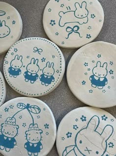 six ceramic plates decorated with cartoon animals and designs on the front, side, and back of each plate