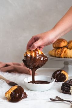 a person dipping chocolate into some pastries