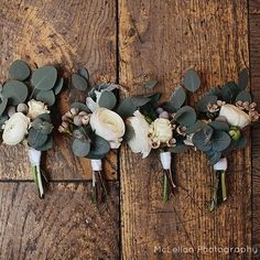 three bridal bouquets with white flowers and greenery laid out on the floor