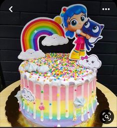 there is a cake with sprinkles on it and a rainbow in the background