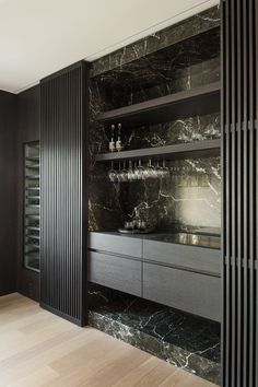 a black and white kitchen with marble counter tops, built - in wine racks and cabinets