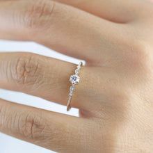 a woman's hand with a diamond ring on it