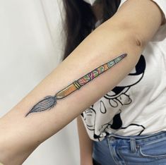 a woman's arm with an arrow tattoo on the left side of her arm