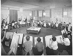 an old black and white photo of people sitting at desks with paper on them