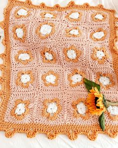 a crocheted blanket with sunflowers on it and a flower in the middle