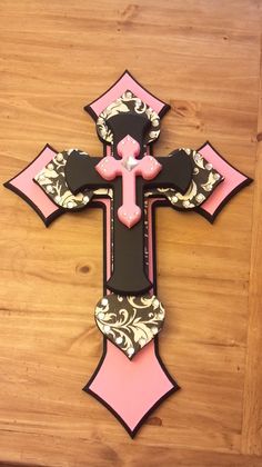 a pink and black cross on a wooden table