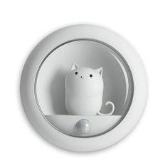 a white cat is sitting in the middle of a round light fixture with its eyes closed