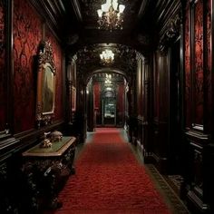 the hallway is lined with red carpet and ornate wood paneling