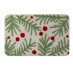 a white door mat with green leaves and red berries on the front, in an evergreen pattern