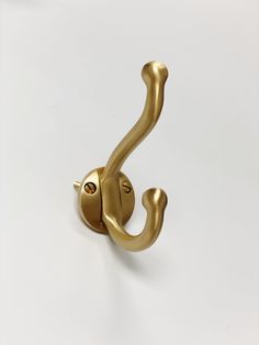 a gold hook on a white wall