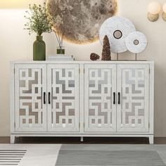 a white cabinet sitting in front of a wall with decorative items on top of it