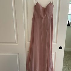 a pink dress hanging on a door