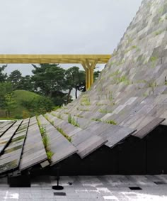 an upside down building with grass growing on the roof and stairs leading up to it