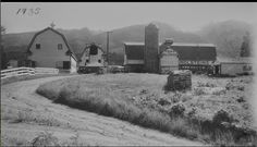 an old black and white photo of farm buildings