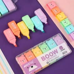 several different colored bear erasers on a purple surface