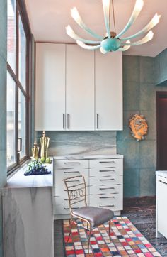 a kitchen with white cabinets and an area rug on the floor that matches the wall