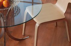 a glass table with some oranges on it and a bowl of fruit in the middle