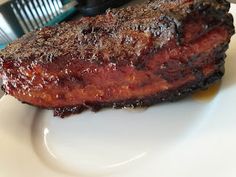 a piece of steak sitting on top of a white plate