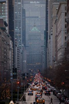 a city street filled with lots of traffic and tall buildings next to eachother