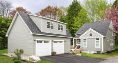 two garages in the middle of a driveway with trees and grass around them,