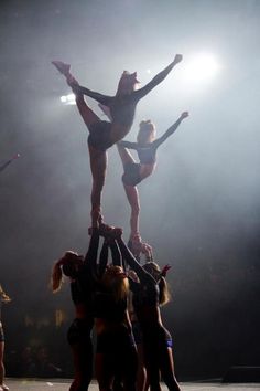 a group of people standing on top of each other in the middle of a dance