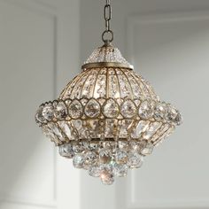 a chandelier hanging from the ceiling with lots of crystal beads on it's sides