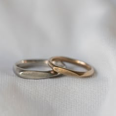 two wedding rings sitting on top of each other