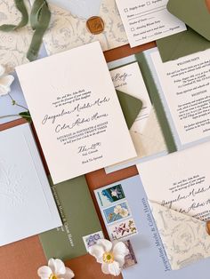 the wedding stationery is laid out on top of each other, including an envelope