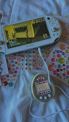 a nintendo wii game system sitting on top of a white bed covered in stickers