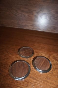 three wooden coasters sitting on top of a wooden table